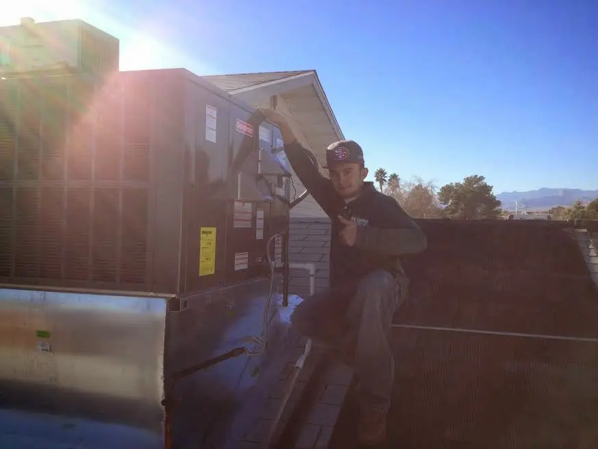 HVAC technician performing AC Tune-Up on a rooftop unit in Robertsdale